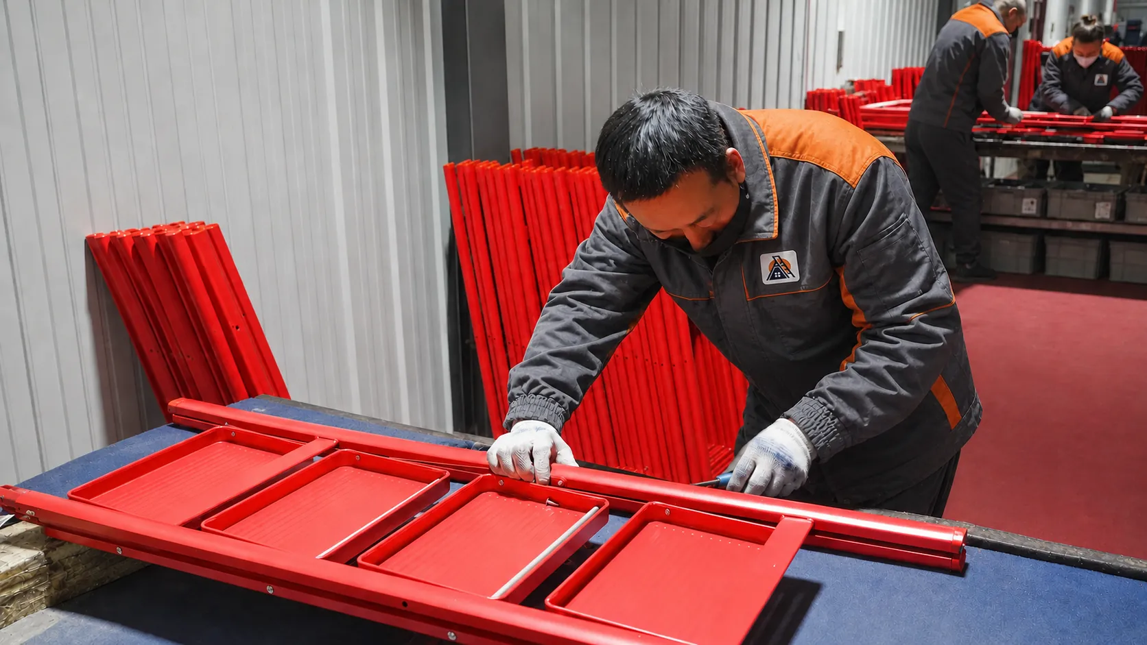 ARIKLIMB factory worker assembling a red step ladder